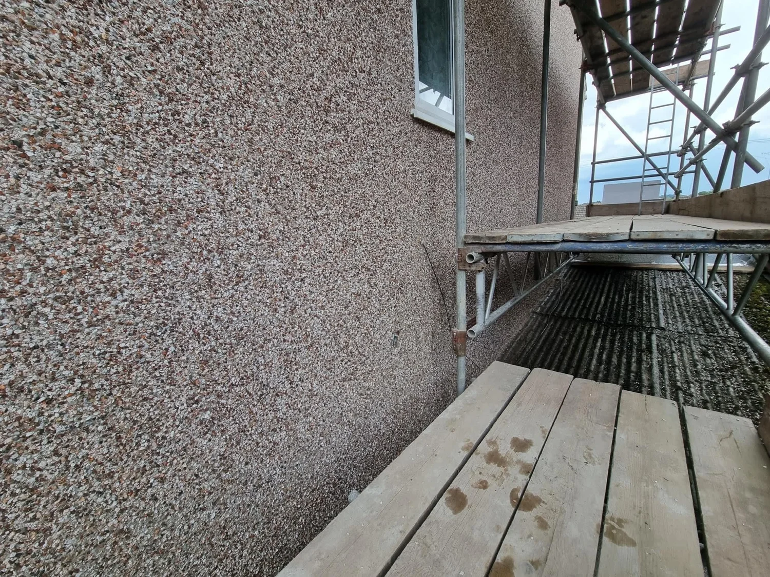 Pebble dash exterior wall beside scaffolding