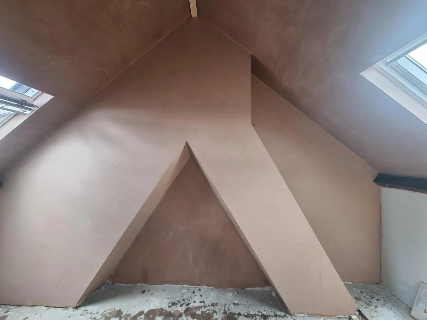 Fresh plaster across loft walls and sloping ceilings